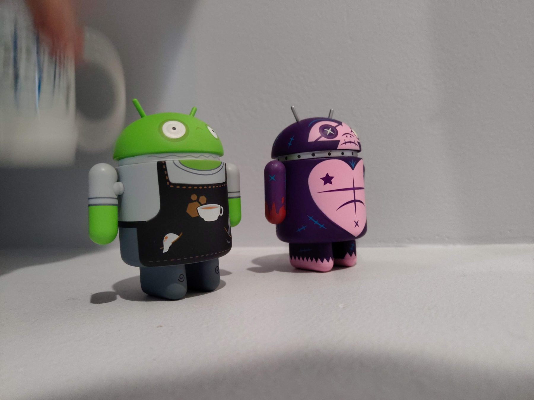 Two collectible Android figures on a shelf in the Mica Specialties office