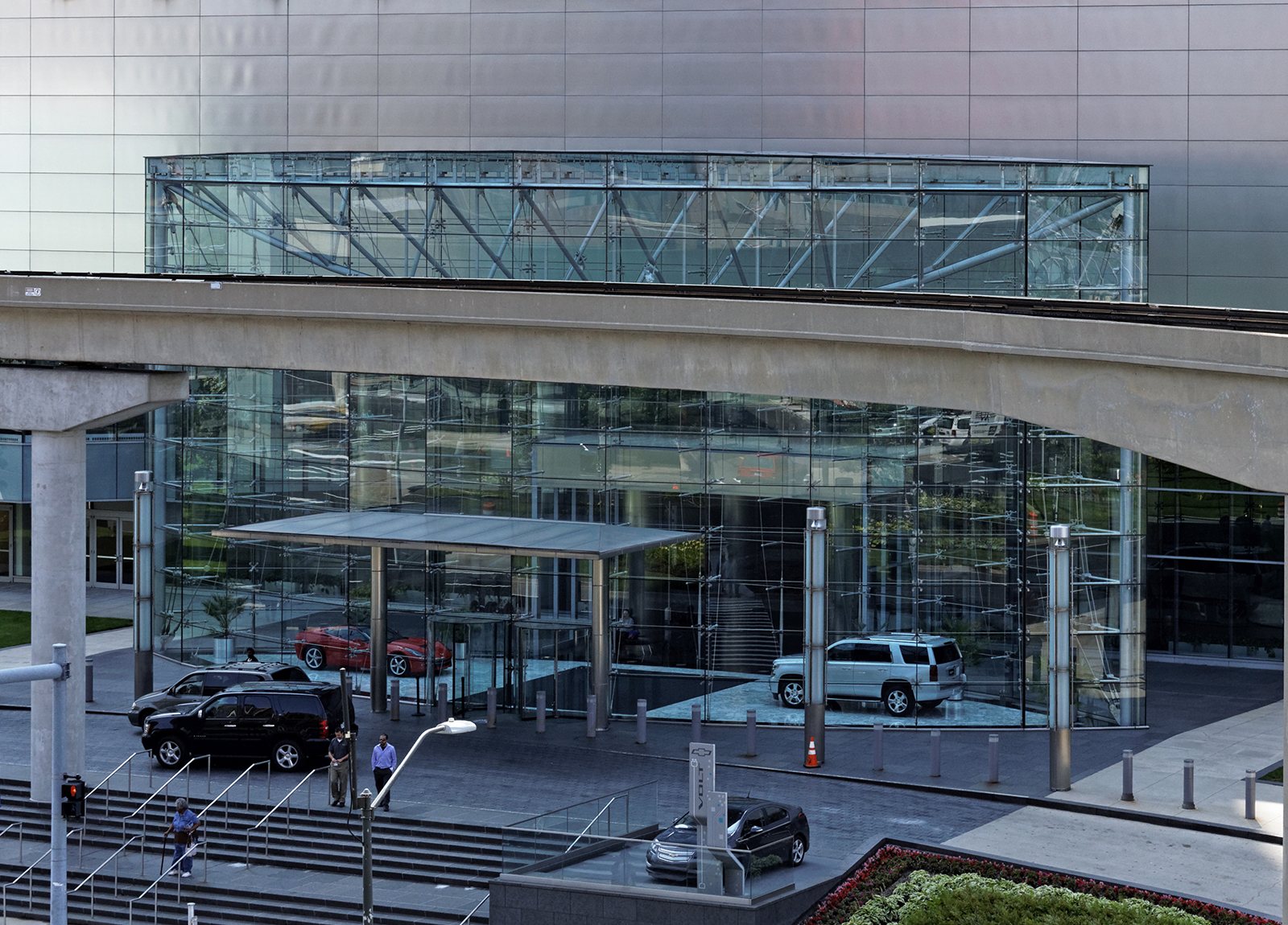 General Motors headquarters glass lobby with a Corvette and Tahoe on display